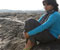 Gul Panaag seating alone at beach stone